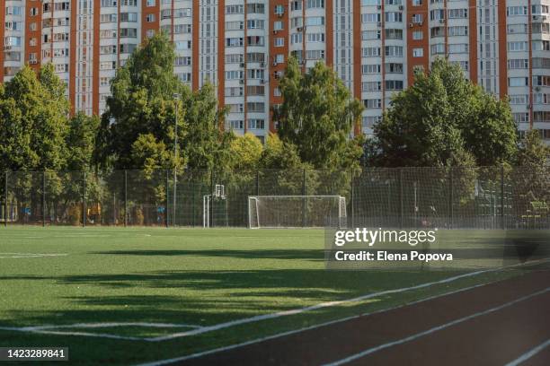 empty football field against residential building - playing fields stock pictures, royalty-free photos & images