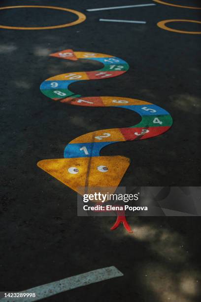 snake shape hopscotch game at the asphalt road, ambient light - sunbeam snake stock pictures, royalty-free photos & images