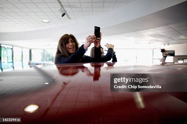 Supporters stand up on new vehicles to take photographs of Republican presidential candidate, former House Speaker Newt Gingrich during a campaign...