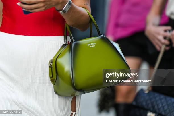 Guest wears a silver watch, a green and black gradient shiny leather handbag from Prada, outside Tibi , during New York Fashion Week, on September...