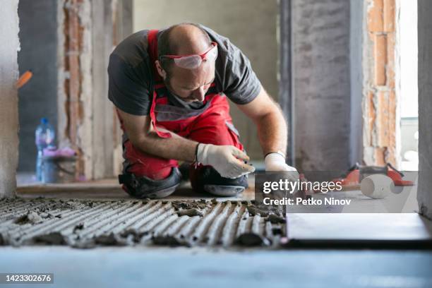 professional builder leveling tiles - tiling stock pictures, royalty-free photos & images