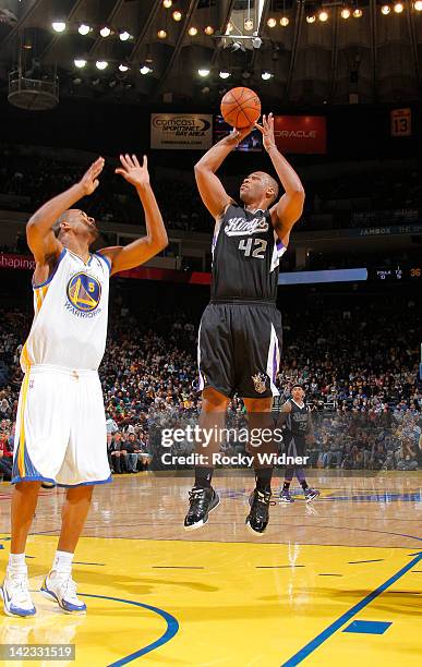 Chuck Hayes of the Sacramento Kings shoots the ball over Dominic McGuire of the Golden State Warriors on March 24, 2012 at Oracle Arena in Oakland,...