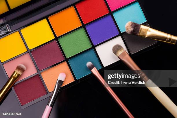 beauty make-up product for a woman makeup brushes and palette eyeshadow on dark black color background. concept of color of the year 2022 very peri lavender purple violet. - yellow eyeshadow stock pictures, royalty-free photos & images