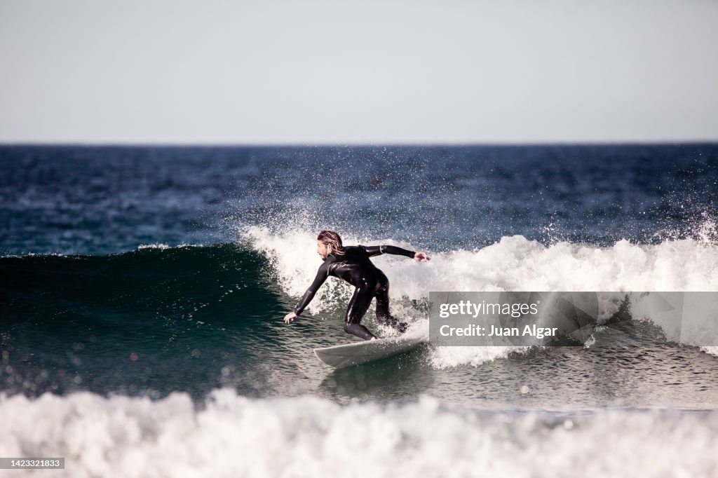 Concentrated male surfer balancing on board while riding wave