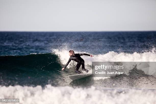 concentrated male surfer balancing on board while riding wave - tide fotografías e imágenes de stock