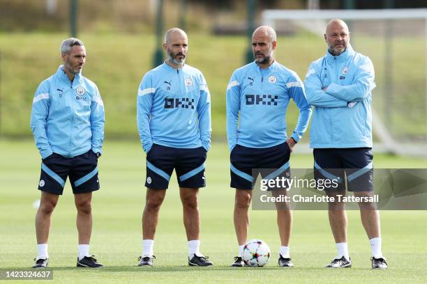 Pep Guardiola, Manager of Manchester City and staff look on during a training session ahead of their UEFA Champions League group G match against...