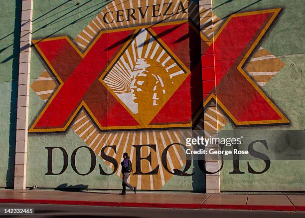 Visitor walks past a giant Dos Equis billboard, located near the Monte Carlo Hotel & Casino, on March 18 in Las Vegas, Nevada. Hit hard by a...