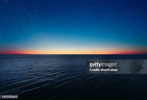 scenic view of star field over sea - stunning early color photography stockfoto's en -beelden