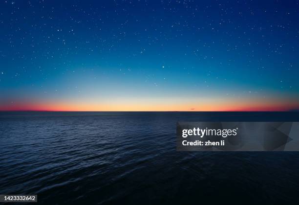 scenic view of star field over sea - sunrise hope stock pictures, royalty-free photos & images