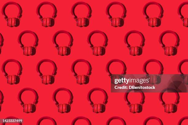 pattern of red wireless headphones with hard shadow on red background. concept of music, earphones, radio, podcast, listening and relaxing activity. - pop music background stock pictures, royalty-free photos & images