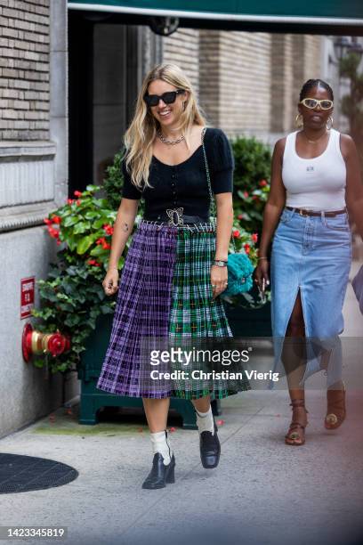Guest wearing Miu Miu two tone checkered skirt outside Coach on September 12, 2022 in New York City.