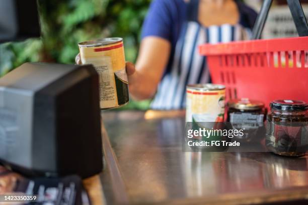 cashier checking out groceries in a supermarket - convenience store counter stockfoto's en -beelden