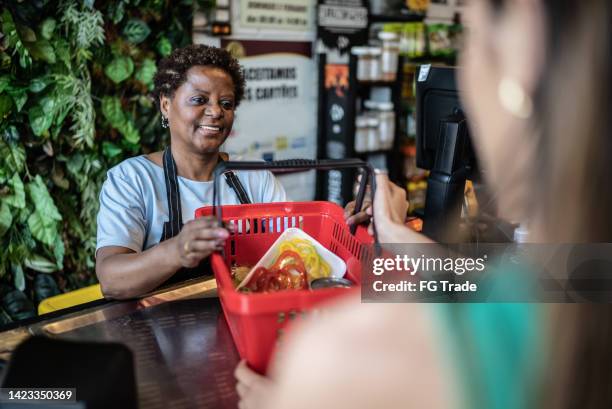 cashier checking out groceries in a supermarket - corner shop stock pictures, royalty-free photos & images