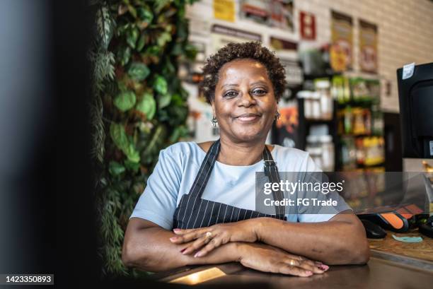 retrato de una cajera senior que trabaja en un mercado - market trader fotografías e imágenes de stock