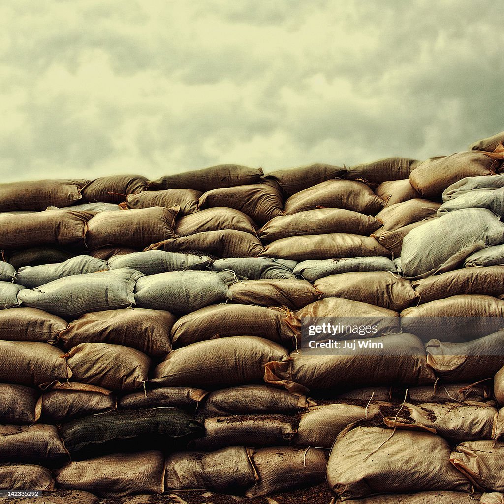 Sandbag levee under stormy sky