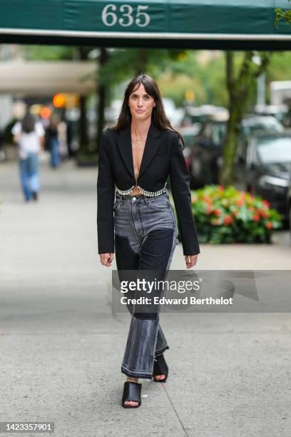 Astrid Boutrot wears a black with embroidered crystal fringed cropped blazer jacket, a silver chain necklace, gray and black bicolored pattern flared...