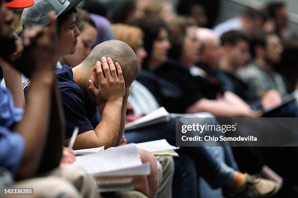 Student rests his head in his hands while listening to Republican Presidential candidate, former House Speaker Newt Gingrich address a campaign town...