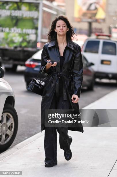 Guest is seen wearing a black trench coat and black striped pants with black bag outside the Veronica Beard show during New York Fashion Week S/S...