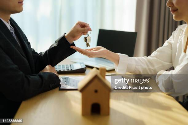 real estate agent with house model and give keys to customer after signing contract to buy house, insurance or loan real estate. - housing loan stock pictures, royalty-free photos & images