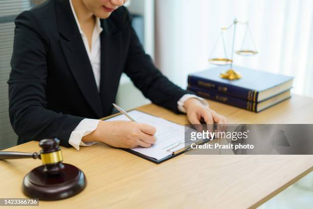 lawyer businesswoman working and notary signs the documents at office. consultant lawyer, justice and law ,attorney, court judge, concept. - judges table stock pictures, royalty-free photos & images