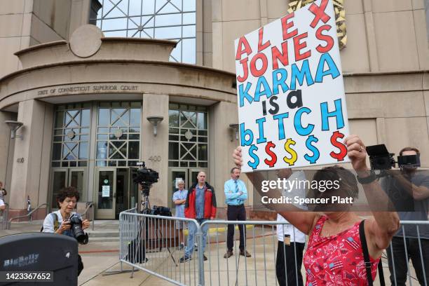 Lone protester stands outside the Waterbury Superior Court during the start of the trial against Alex Jones who called the 2012 Sandy Hook shooting a...