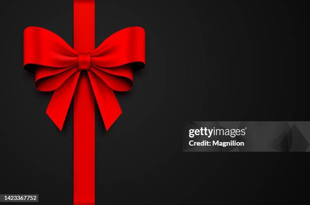 red gift bow with ribbon on a black background - red bow stock illustrations