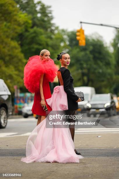 Leonie Hanne wears gold earrings, a red short dress with oversized ruffled tulle shoulder, a gold Juste Un Clou bracelet from Cartier, a gold and...