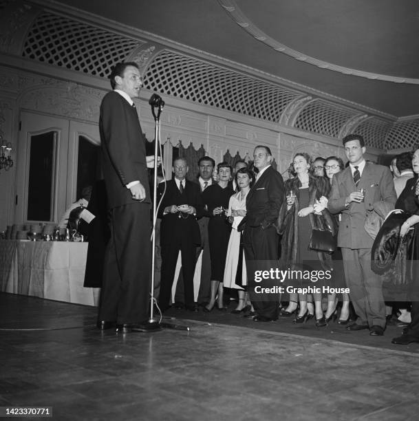 American singer and actor Frank Sinatra sings for guests attending the after party which the Los Angeles premiere of 'Meet Danny Wilson, ' held in...