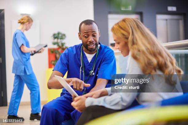 doctor explaining to patient's relative - outpatient care stock pictures, royalty-free photos & images