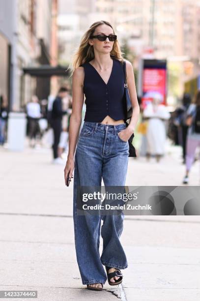 Model is seen wearing a blue vest, blue jeans and black sunglasses outside the Veronica Beard show during New York Fashion Week S/S 2023 on September...