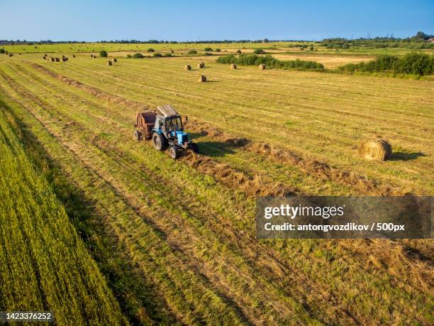 tractor bailing dry grass in countryside - bailing hay stock pictures, royalty-free photos & images