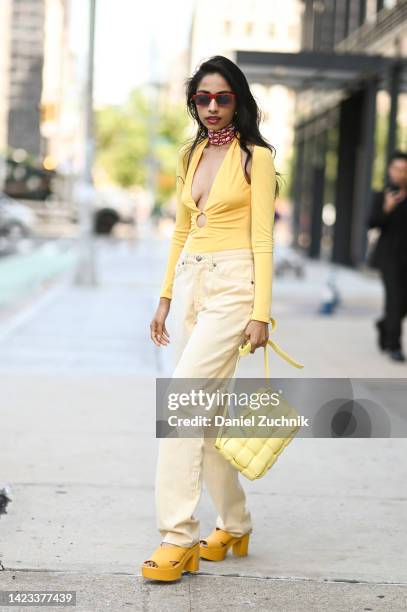 Malvika Sheth is seen wearing a yellow Michael Costello top, Roberto Cavalli jeans, Vivienne Westwood x Melissa shoes, Bottega Veneta bag and...