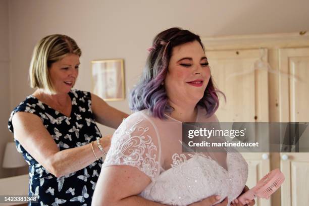 body positive future bride getting dressed with mother before lgbtq+ wedding. - bride getting dressed stock pictures, royalty-free photos & images