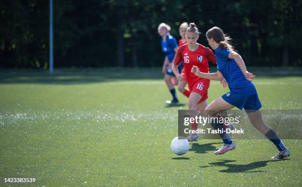 shot of determined female soccer player kicking the ball on  a match - shooting football stock pictures, royalty-free photos & images