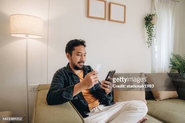 mature man using cellphone for shopping online - debit cards credit cards accepted stock pictures, royalty-free photos & images