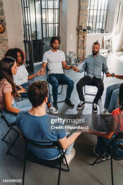 menschen meditieren zusammen während einer gruppentherapiesitzung - anonyme alkoholiker stock-fotos und bilder
