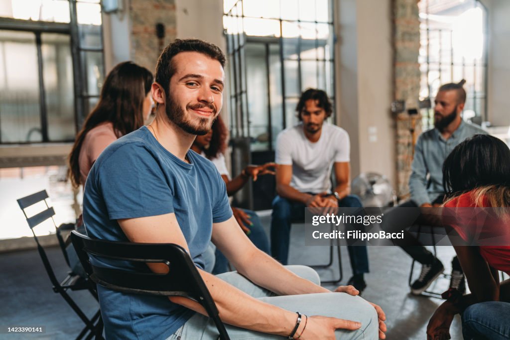 Portrait of a man looking at camera during a group therapy session