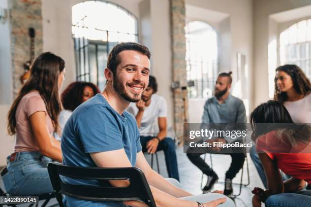 retrato de um homem olhando para a câmera durante uma sessão de terapia em grupo - abuso de substâncias - fotografias e filmes do acervo