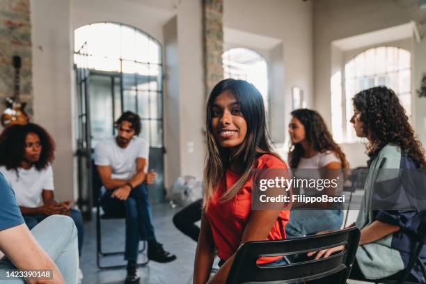 portrait of a woman looking at camera during a group therapy session - sri lankan ethnicity stock pictures, royalty-free photos & images