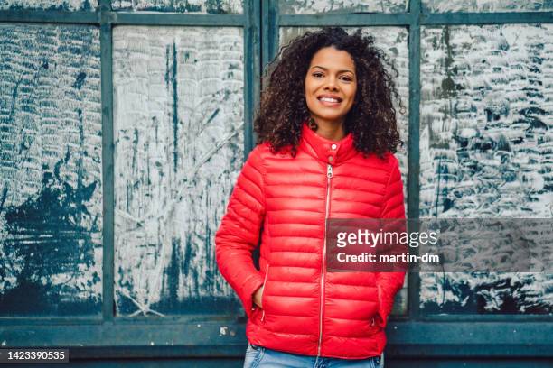 femme de race mixte heureuse - puffer jacket photos et images de collection