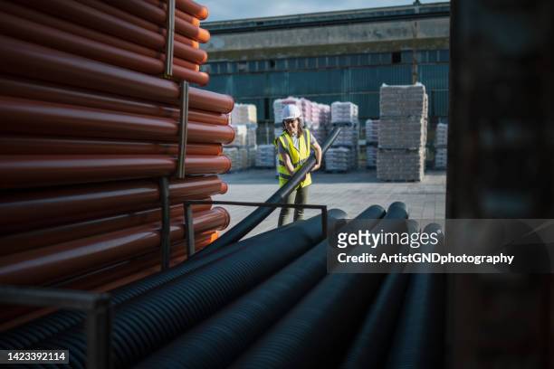 female working in a building materials supply store. - pipe tube stock pictures, royalty-free photos & images