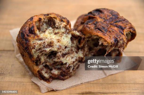 chocolate babka loaf on a paper napkin on a wooden cafe table - sweet bread fotografías e imágenes de stock