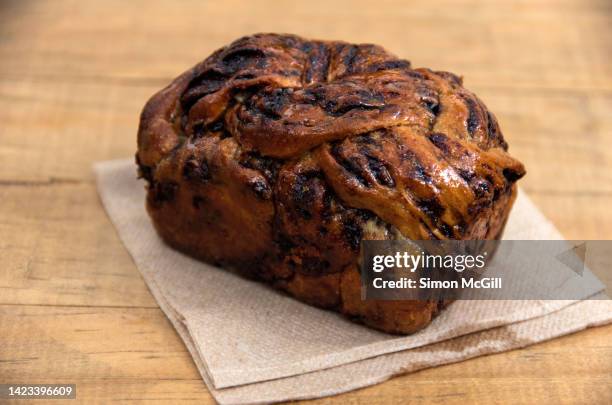 chocolate babka loaf on a paper napkin on a wooden cafe table - easter cake stock pictures, royalty-free photos & images