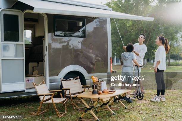 asian chinese family setting up awning on a caravan - family caravan stock pictures, royalty-free photos & images