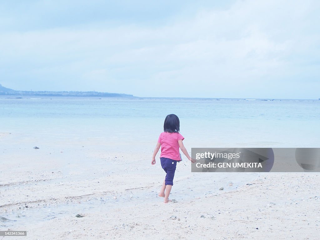 Small girl running along beach