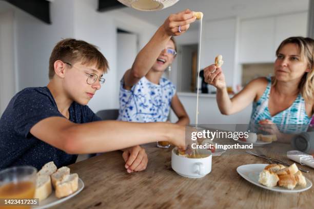 famiglia che si gode il pranzo con fonduta a casa - lunch cheese foto e immagini stock