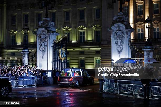 The hearse carrying the flag-draped casket of Queen Elizabeth II enters the center gate at Buckingham Palace on September 13, 2022 in London,...