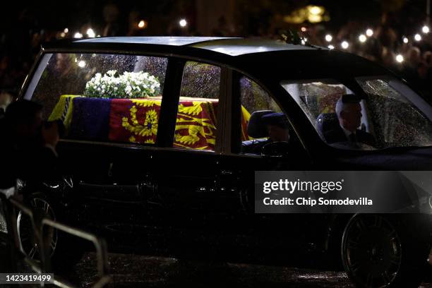 The hearse carrying the flag-draped casket of Queen Elizabeth II enters the center gate at Buckingham Palace on September 13, 2022 in London,...