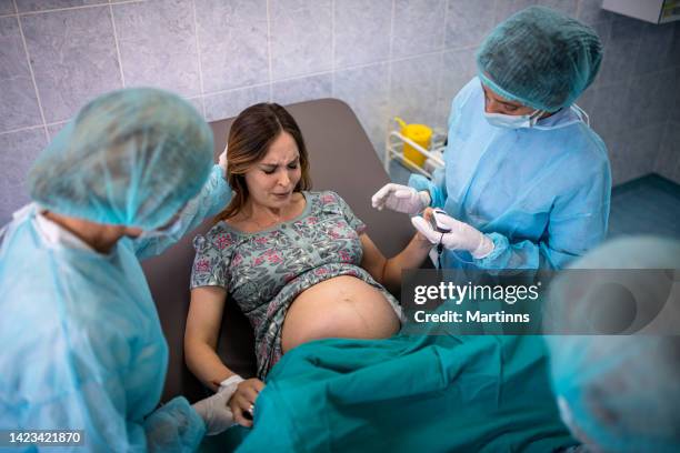 in the hospital woman giving birth support, obstetricians assisting. modern delivery ward with professional midwives - woman-screaming-giving-birth stock pictures, royalty-free photos & images
