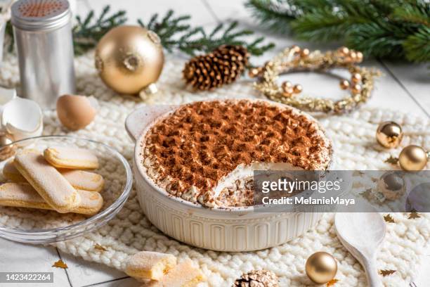 festliches weihnachtsdessert tiramisu biskuitkuchen in heller rustikaler küche mit goldenem weihnachtsschmuck - tiramisu stock-fotos und bilder